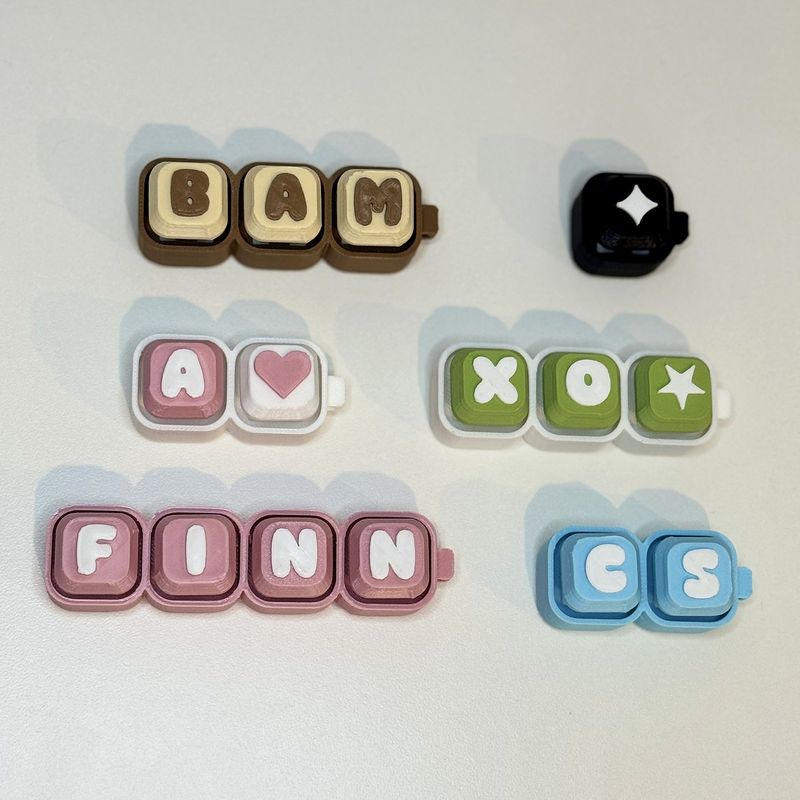 Name keychains spelling BAM, FINN, CS and XO in different colourways