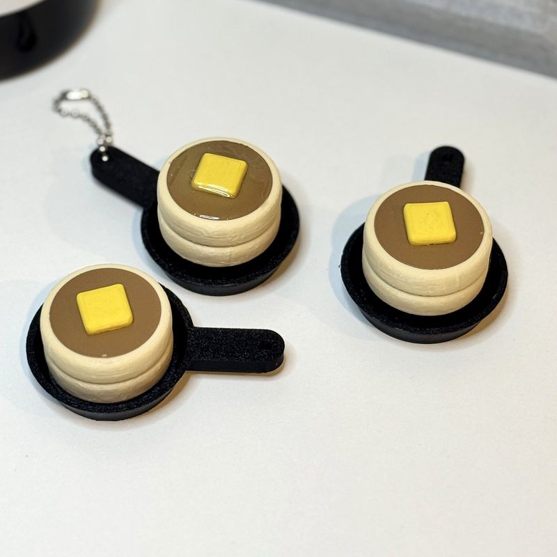Three pancake stack keychains in little black frying pans